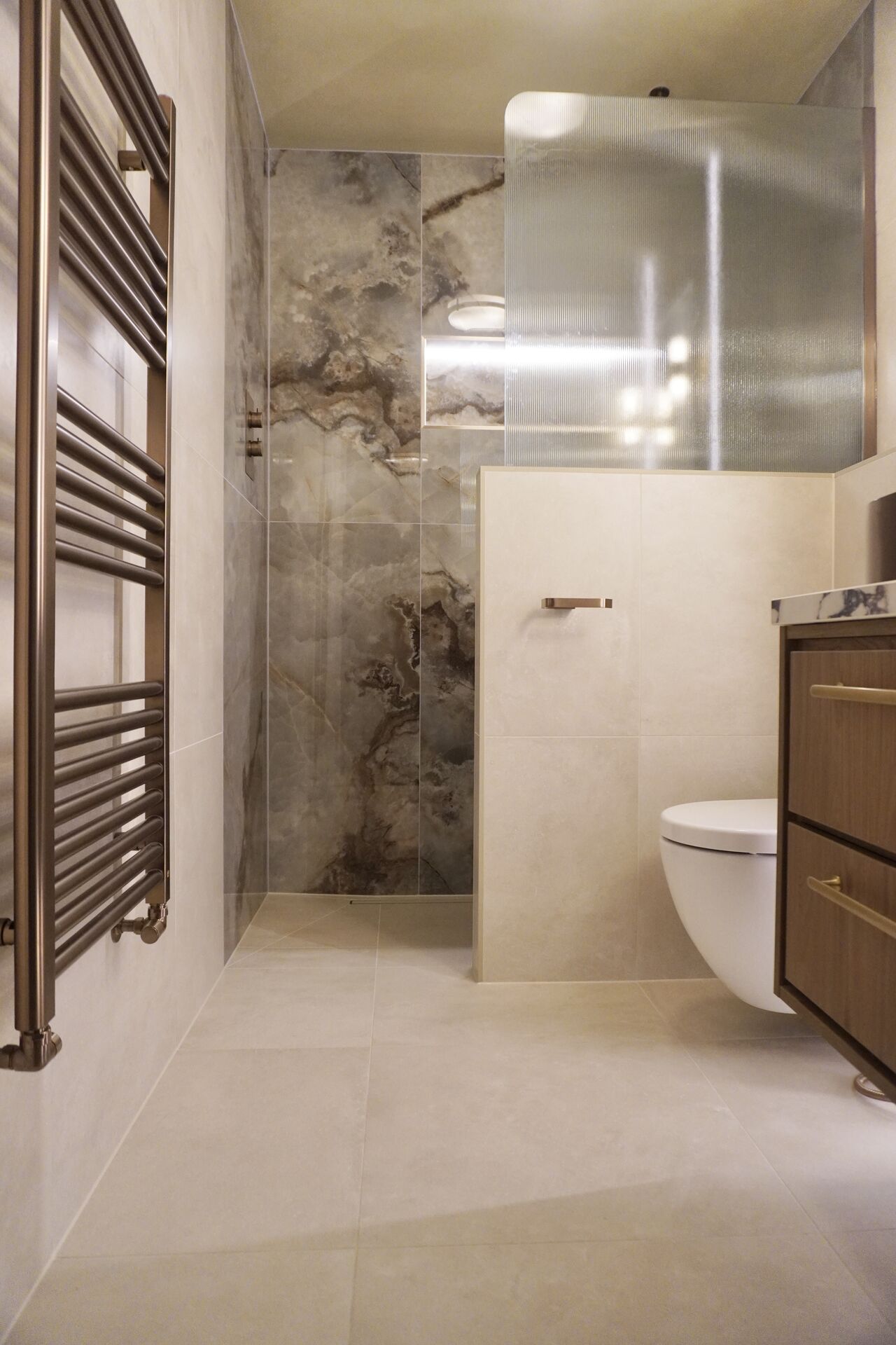 Walk-in shower finished in book-matched marble